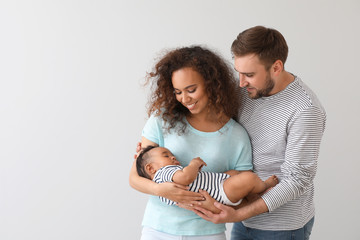 Portrait of happy interracial family on light background