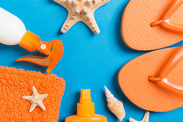 Top view of Beach flat lay accessories. sunscreen bottle with seashells, starfish, towel and...
