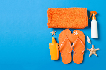 Top view of Beach flat lay accessories. sunscreen bottle with seashells, starfish, towel and...