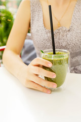 Green juice smoothie healthy drink breakfast shake. Woman drinking weight loss food diet banner. Hand holding cold beverage glass.