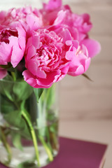 Vase with beautiful peony flowers on table