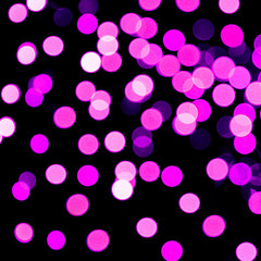 Unfocused abstract purple bokeh on black background. defocused and blurred many round light