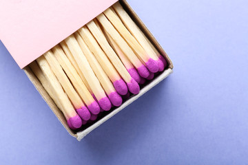 Box with matches on color background