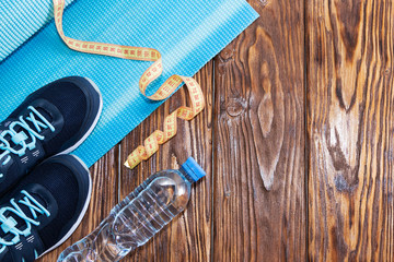 Healthy lifestyle and sports background. Sports shoes and water bottle on wooden background with copyspace, topview.