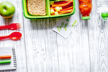 kid menu lunchbox for school top view on wooden background