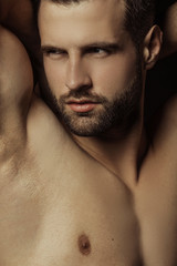 Fototapeta premium Handsome sport sexy stripped guy portrait in a water draps and fog smoke mist on isolated black background