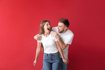 Portrait of happy young couple on color background