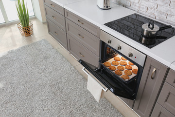 Open oven with tasty homemade cookies in kitchen