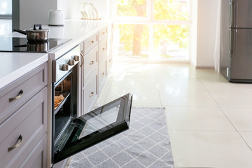 Open oven with tasty homemade cookies in kitchen