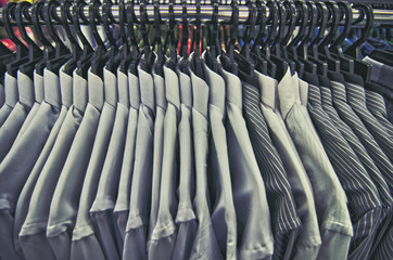selection of clothes for men hanging on hangers in shopping mall for store sale concept