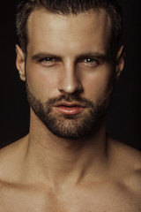 Obraz premium Handsome sport sexy stripped guy portrait in a water draps and fog smoke mist on isolated black background