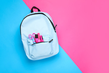 School backpack with stationery on color background - obrazy, fototapety, plakaty