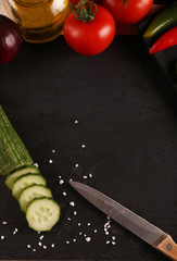 Healthy food. Vegetables on a black plate and stone cutting board and wooden background. Top View and copy space.