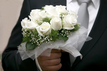 beautiful wedding bouquet of white roses in hand of bride