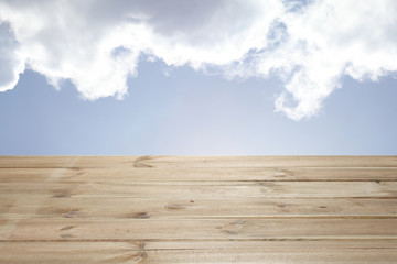 wooden table with with cloudy sky background and copy space for your text