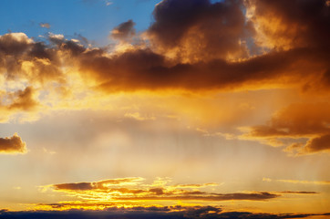 Storm clouds at golden sunset and red sun.
