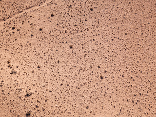 Aerial view of a desert landscape on the island of Lanzarote, Canary Islands, Spain. Desert background, texture. Sand and desolate land