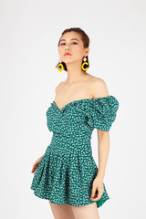 Asian Chinese Fashion influencer modeling in a green dotted dress isolated in white background