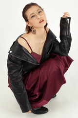 Asian Chinese Fashion influencer modeling in a wine color silk dress and leather jacket isolated in...