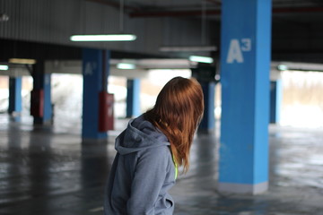 Girl with red hair in gray hoodie. Street style. Advertising brand clothing. Fashion Shooting