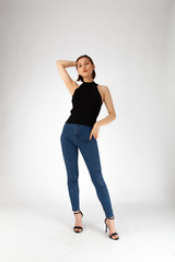 Asian Chinese Fashion influencer modeling in black top and tight jeans isolated in white background