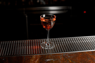 Delicious cocktail in the glass standing on the steel bar counter