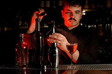 Bartender spraying from the diffuser on the delicious cocktail in the glass