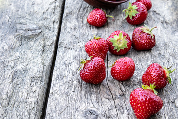 ripe red strawberries scattered on the table.
