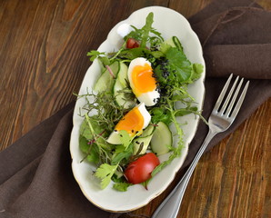 Cucumber, tomato, egg, fresh green salad with black sesame, view from above, copy space