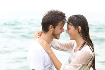 Happy couple ready to kiss bathing on the beach