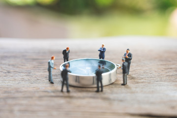 Miniature people businessmen analyze standing on compass as background strategy concept and...