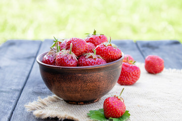 a bowl full of fresh strawberries on a burlap.