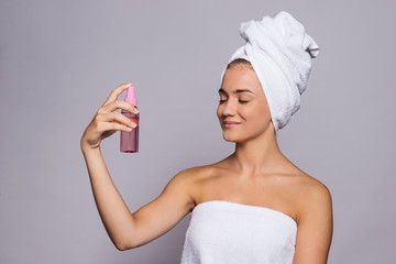 A portrait of young woman with spray in a studio, beauty and skin care.