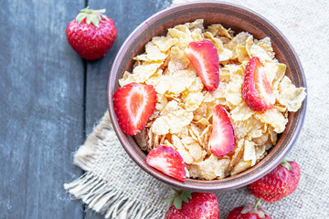 Fresh homemade muesli, muesli with strawberries in a plate on a dark gray background, selective focus