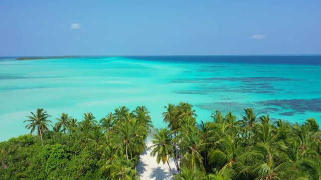 Philippines: aerial view of a small island in the sea of the Philippines with a white sand trail cutting the island in the middle. A gentle breeze is moving the pam tree leaves