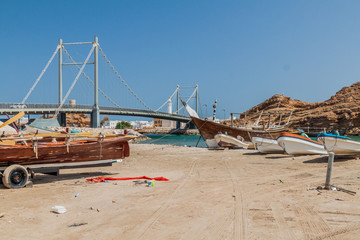 Fototapeta na wymiar Fishing boats in Sur, Oman. Khor al Batar bridge in the background.