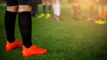 boy soccer players are put multi color sport shoes and standing on green artificial turf with coach © Koonsiri