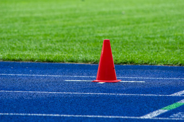 traffic cone on blue tartan track in stadium 
