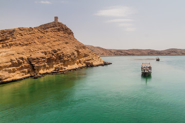 Fototapeta na wymiar Small boat and a watch tower in Ayjah village near Sur, Oman