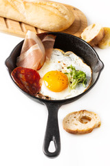 Food Breakfast concept fried egg in skillet iron pan with flax sprouts and bacon with copy space