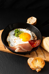 Food Breakfast concept fried egg in skillet iron pan with flax sprouts and bacon with copy space