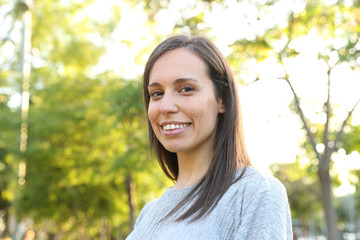 Happy adult woman looking at camera in a park