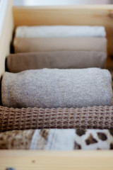 shelf with warm knit clothing brown, folded vertically closeup