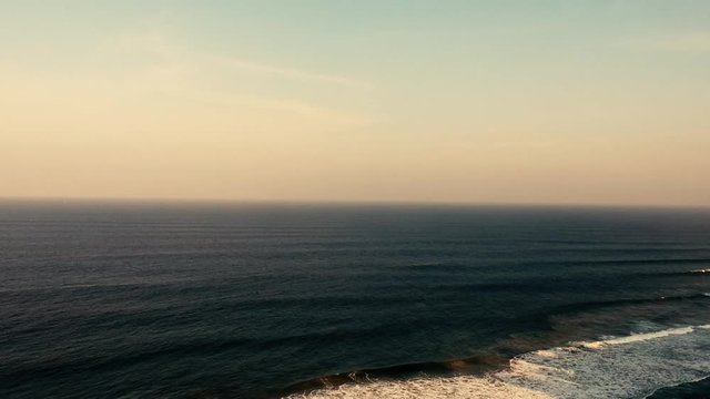 Aerial footage filmed with a drone overlooking the beach and sea of crashing waves with a deep blue ocean on the Bluff in Africa southern hemisphere.