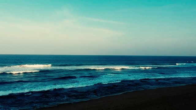 Aerial footage filmed with a drone overlooking the beach and sea of crashing waves with a deep blue ocean on the Bluff in Africa southern hemisphere.