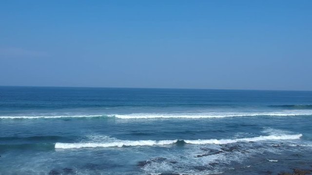 Aerial footage filmed with a drone overlooking the beach and sea of crashing waves with a deep blue ocean on the Bluff in Africa southern hemisphere.