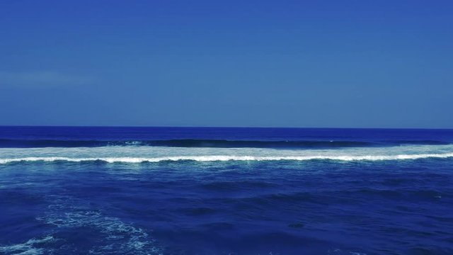 Aerial footage filmed with a drone overlooking the beach and sea of crashing waves with a deep blue ocean on the Bluff in Africa southern hemisphere.