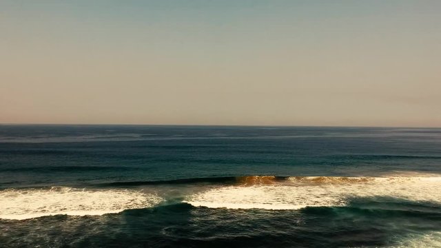 Aerial footage filmed with a drone overlooking the beach and sea of crashing waves with a deep blue ocean on the Bluff in Africa southern hemisphere.