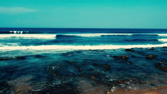 Aerial footage filmed with a drone overlooking the beach and sea of crashing waves with a deep blue ocean on the Bluff in Africa southern hemisphere.