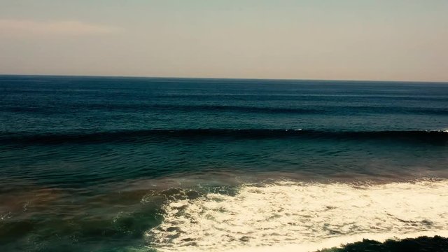 Aerial footage filmed with a drone overlooking the beach and sea of crashing waves with a deep blue ocean on the Bluff in Africa southern hemisphere.
